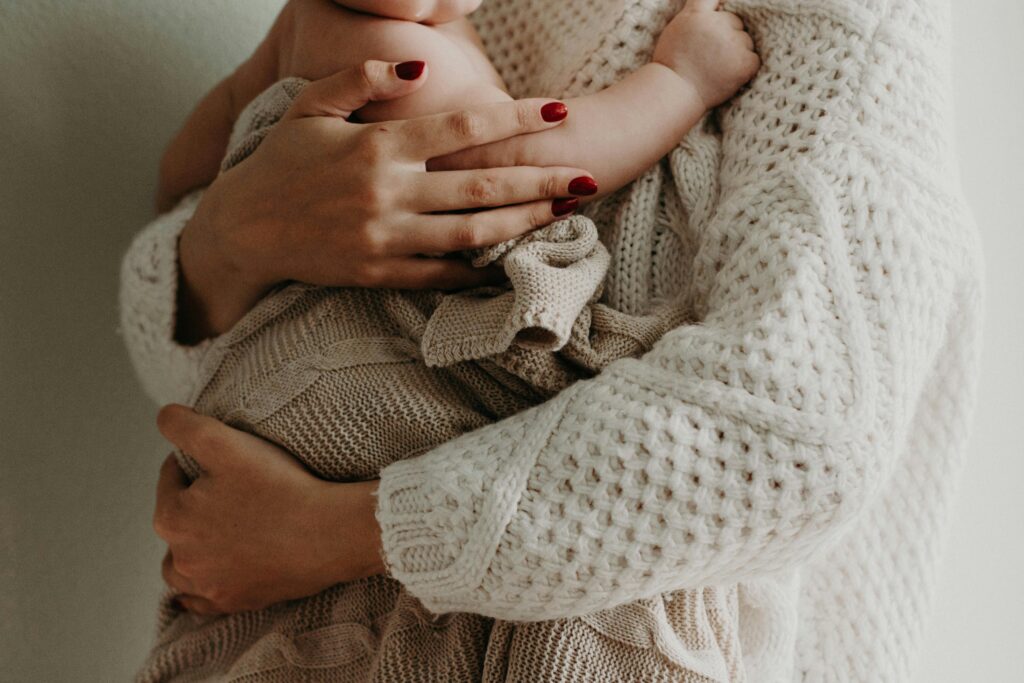 pexels-photo-3270224-3270224 Close-up of a mother holding her baby in warm knitwear, conveying love and togetherness.